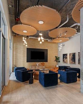 A modern living room with a television, sofas, and a unique ceiling lighting design.